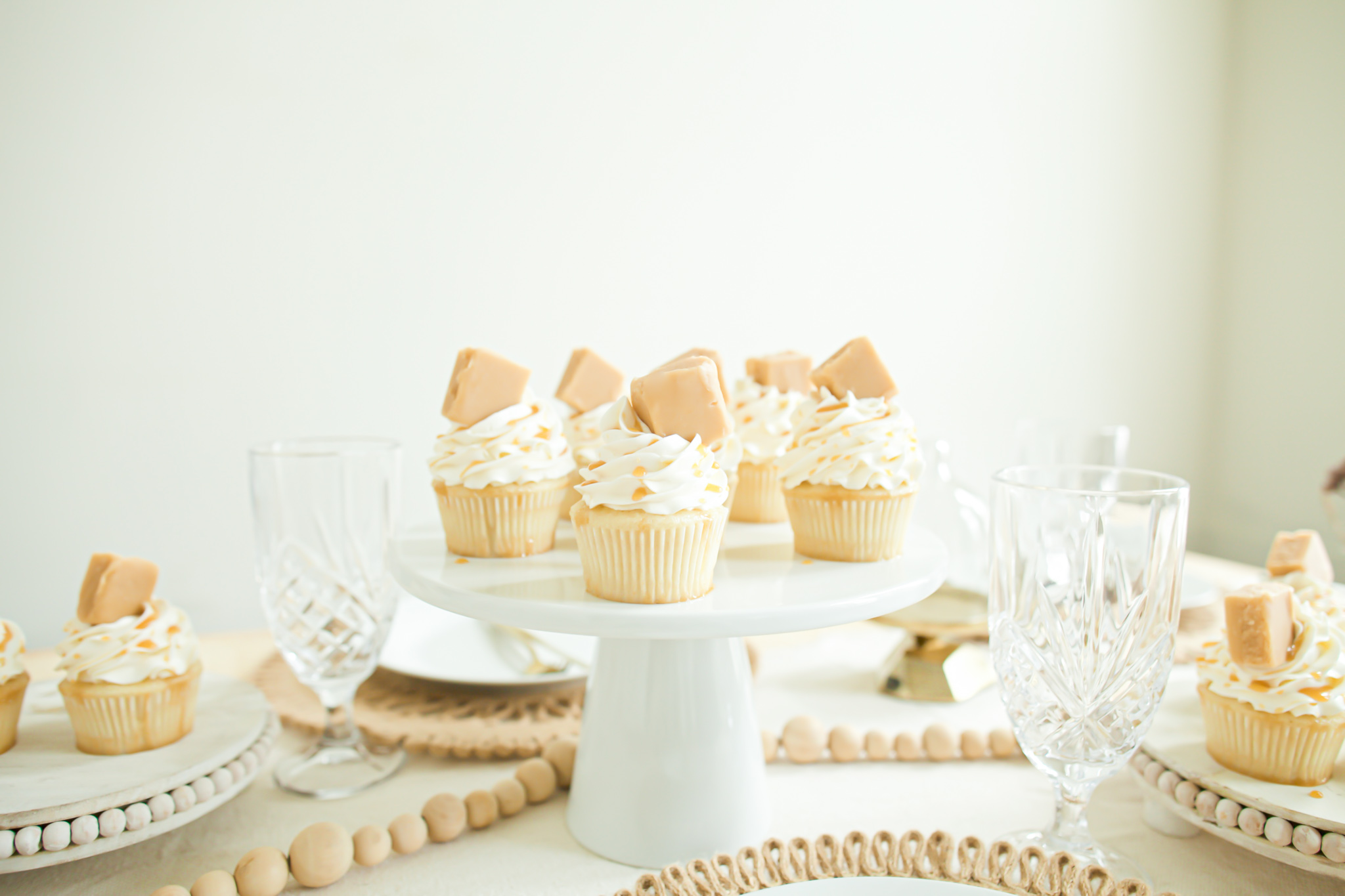 salted caramel cupcakes with vanilla fudge on white cake platter