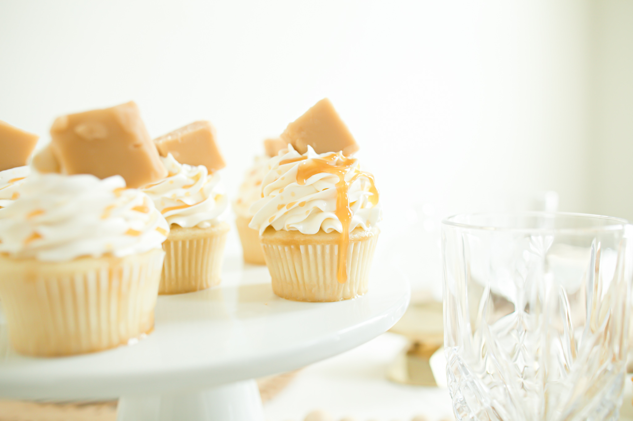 salted caramel cupcakes with vanilla frosting and vanilla fudge for garnish on decorated boho table