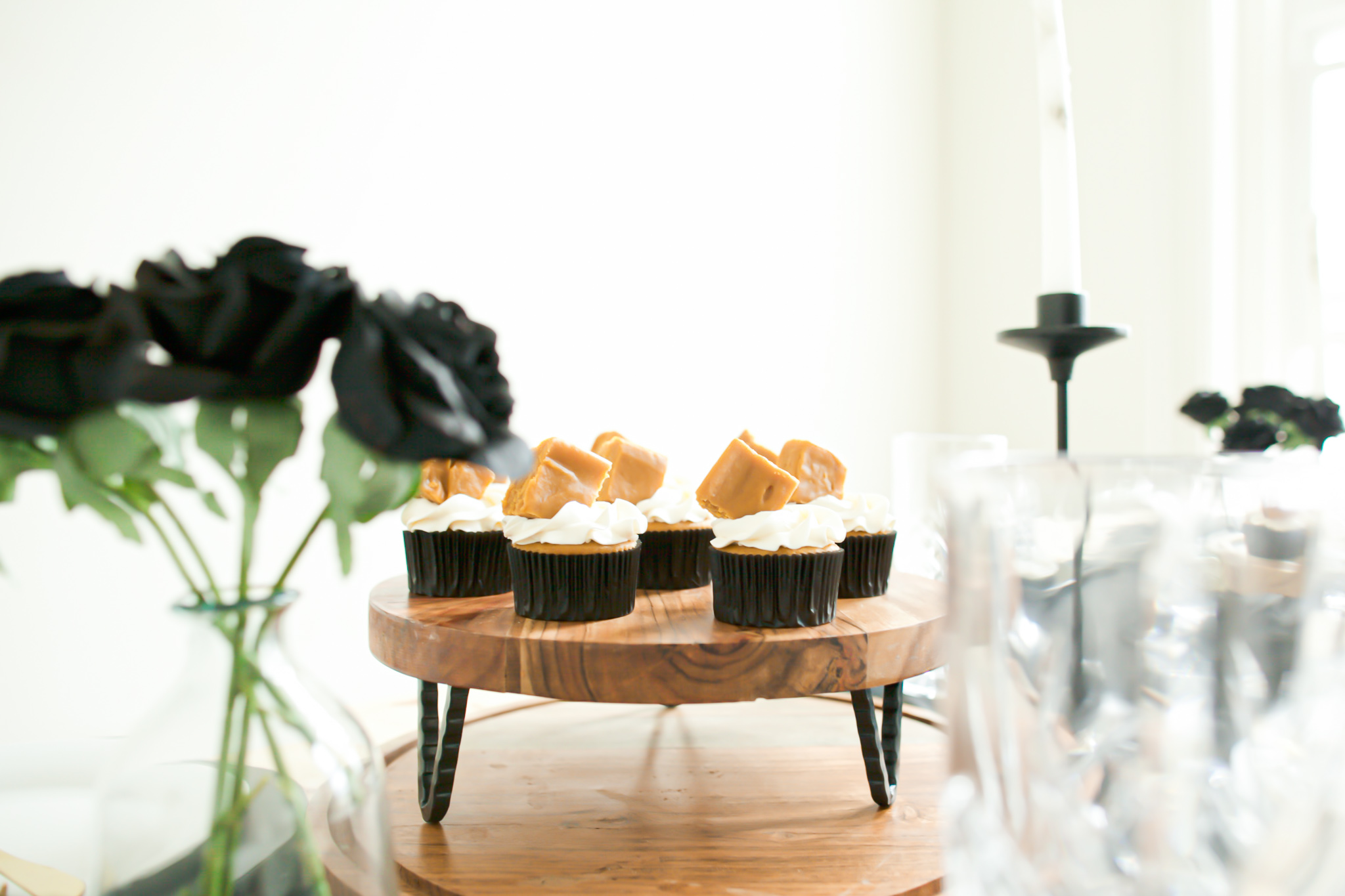 pumpkin cupcakes on wooden cake platter with pumpkin fudge