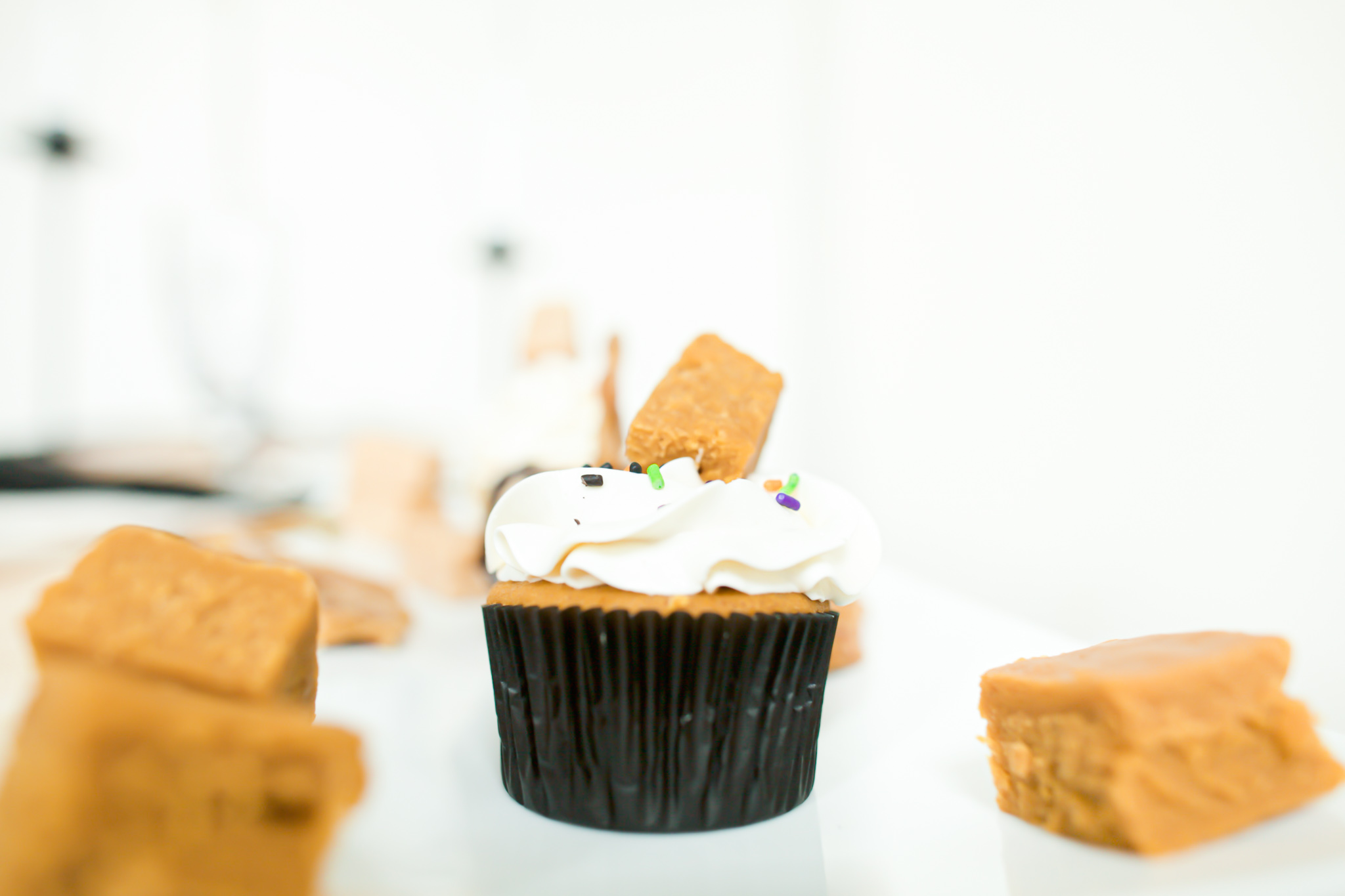 pumpkin cupcakes with white frosting and pumpkin fudge